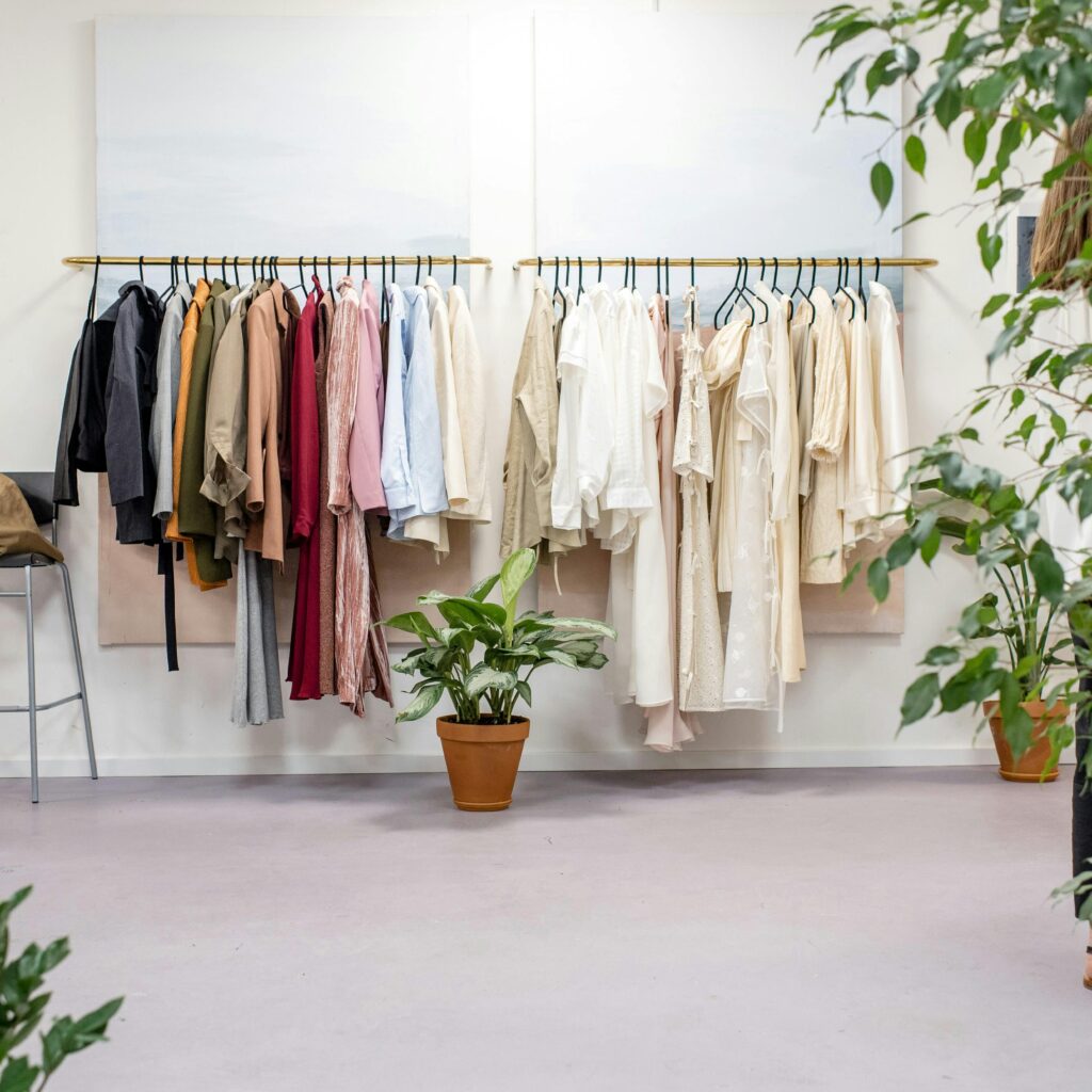 Chic fashion boutique showcasing vibrant clothing collection with lush indoor plants.